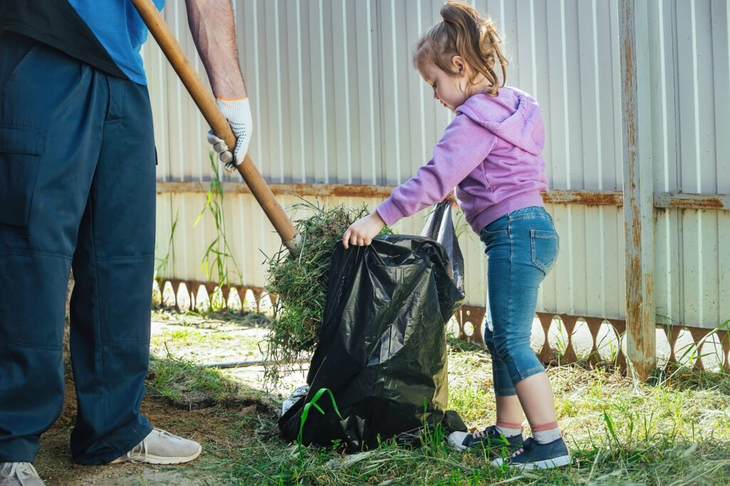 adults and children do household chores together, clean the leaves in the yard