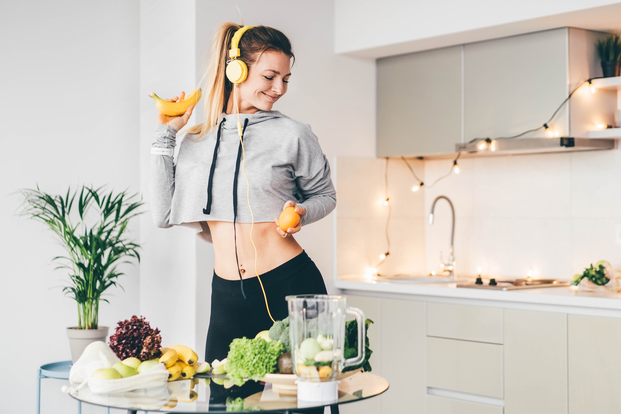 Emotional woman dancing in kitchen while preparing green smoothie. Emotional woman dancing in kitchen while preparing green smoothie.