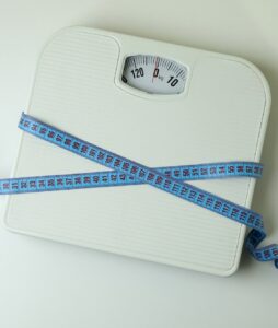 Scales with measuring tape on white background